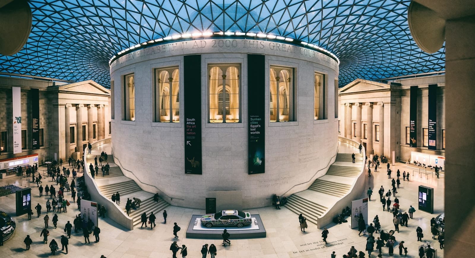 Vista panorâmica do icônico Great Court do British Museum, cheio de visitantes sob um impressionante teto de vidro, transmitindo a grandiosidade e a energia dos principais museus de Londres.