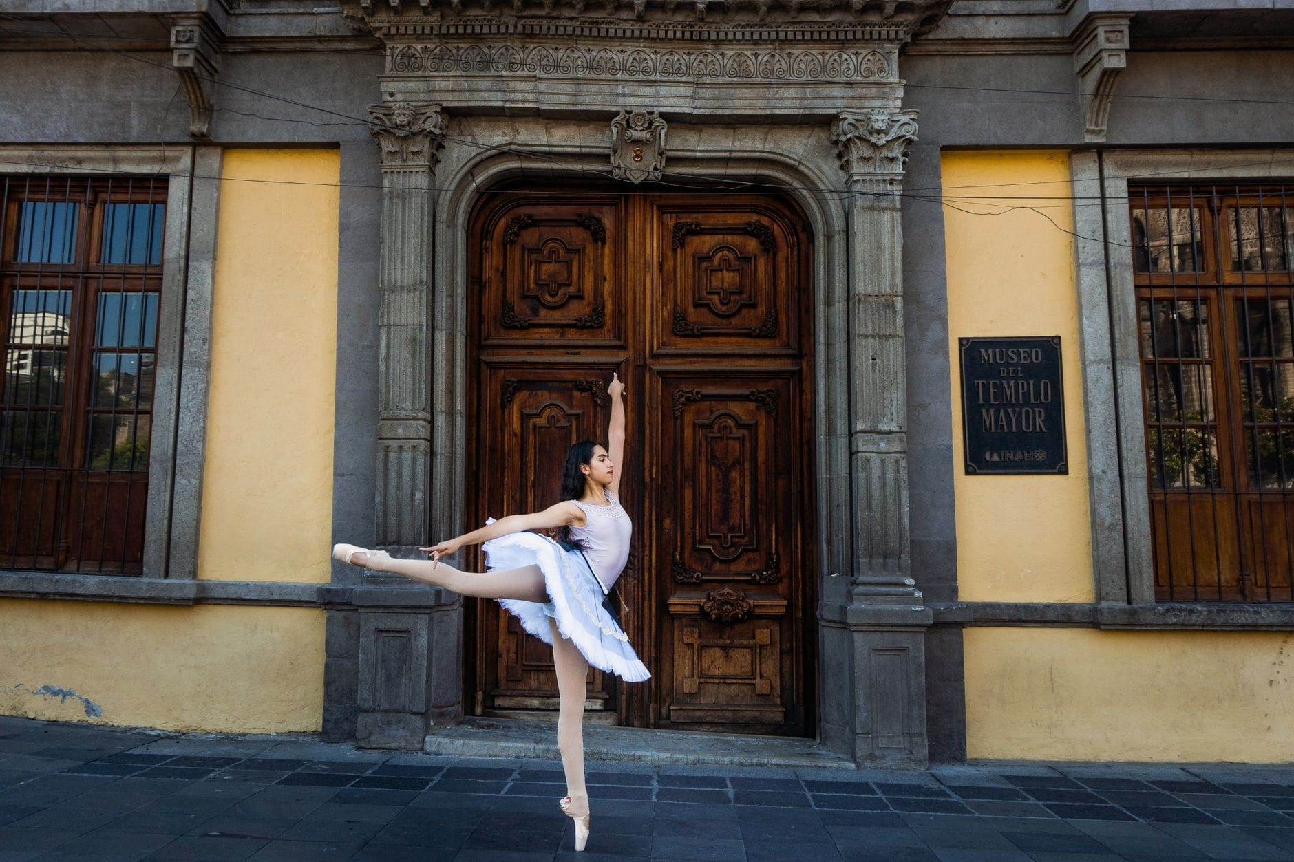 Uma bailarina posa em frente à entrada do Museo del Templo Mayor na Cidade do México, um importante museu arqueológico.