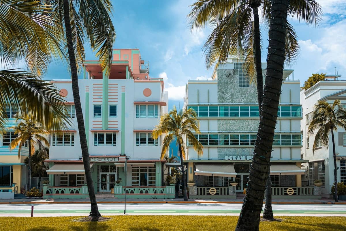 Classic pastel Art Deco buildings and palm trees on Miami Beach's Ocean Drive under a bright sky