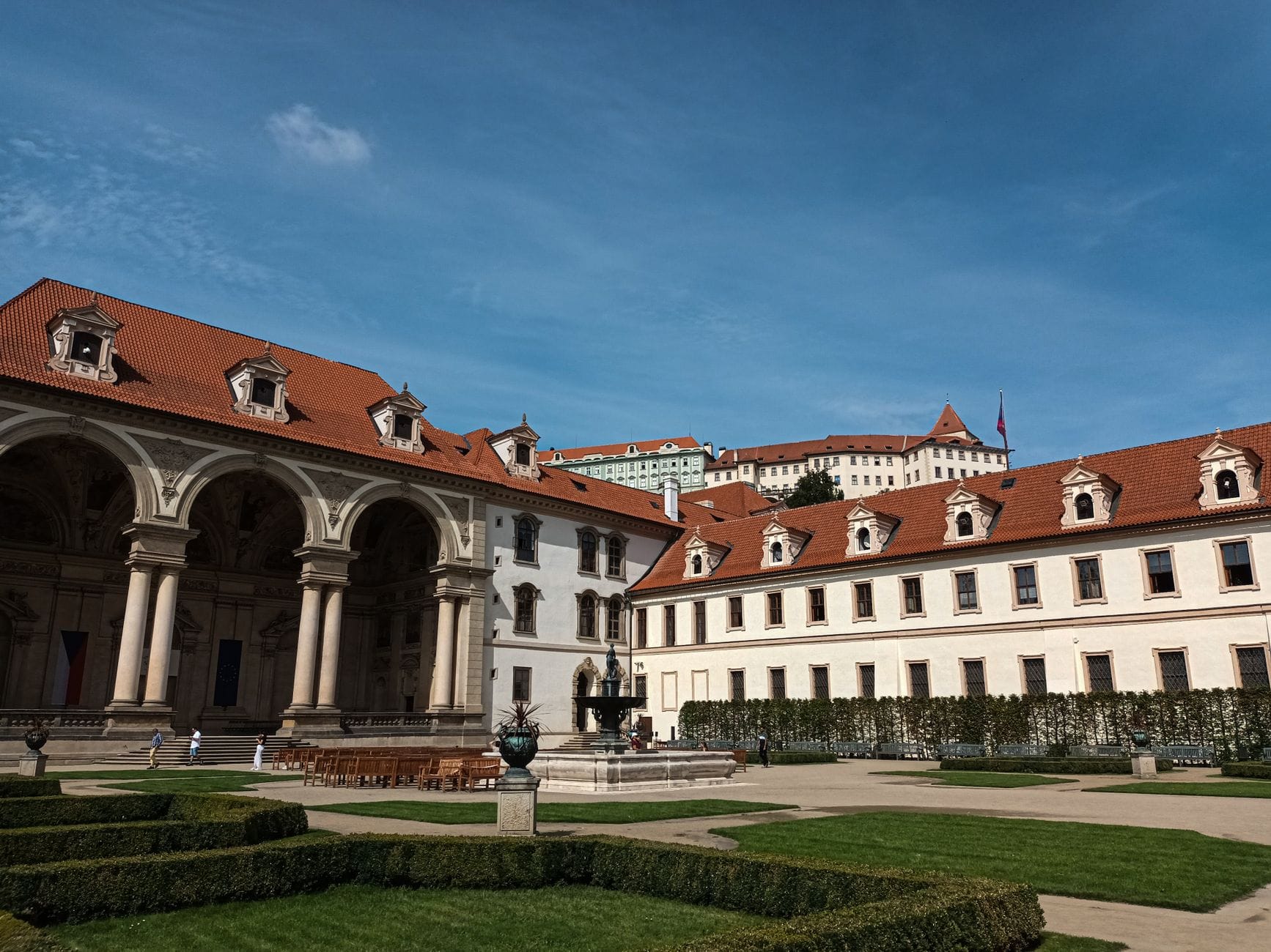 Elegante edifício em estilo palaciano com colunata em arco e pátio bem cuidado, provavelmente um dos históricos museus de arte ou galerias de Praha.
