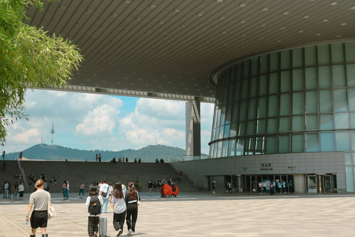 Exterior moderno do Museu Nacional da Coreia com visitantes caminhando em direção à grande entrada de vidro.