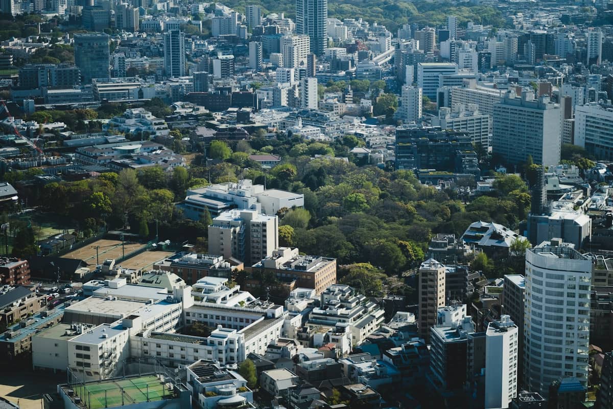 Aerial view of Ueno district in Tokyo with clusters of buildings and visible green park area, representing Tokyo museum neighborhoods.