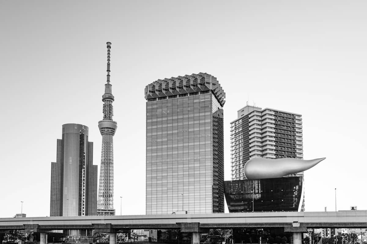 Tokyo skyline with Tokyo Skytree and Asahi Beer Hall featuring its iconic golden flame, representing iconic modern architecture in Tokyo.