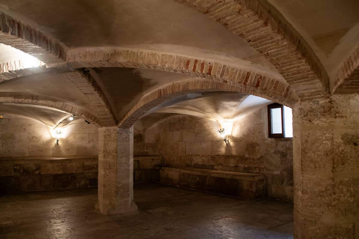 Unterirdischer Raum mit Steingewölbe, Rundbögen und Säulen, typisch für historische oder archäologische Stätten in Valencia, Spanien.