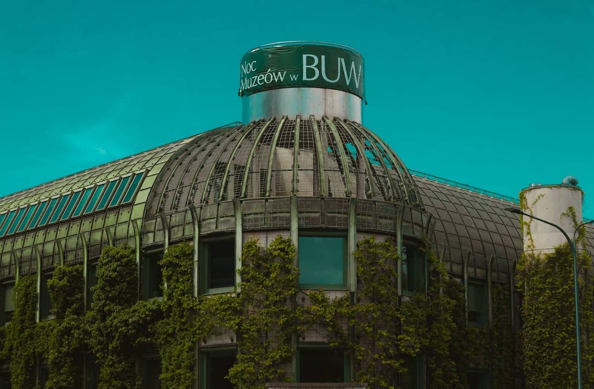 Eksterior Perpustakaan Universitas Warsawa BUW dengan arsitektur hijau yang unik dan taman atap di bawah langit cerah.