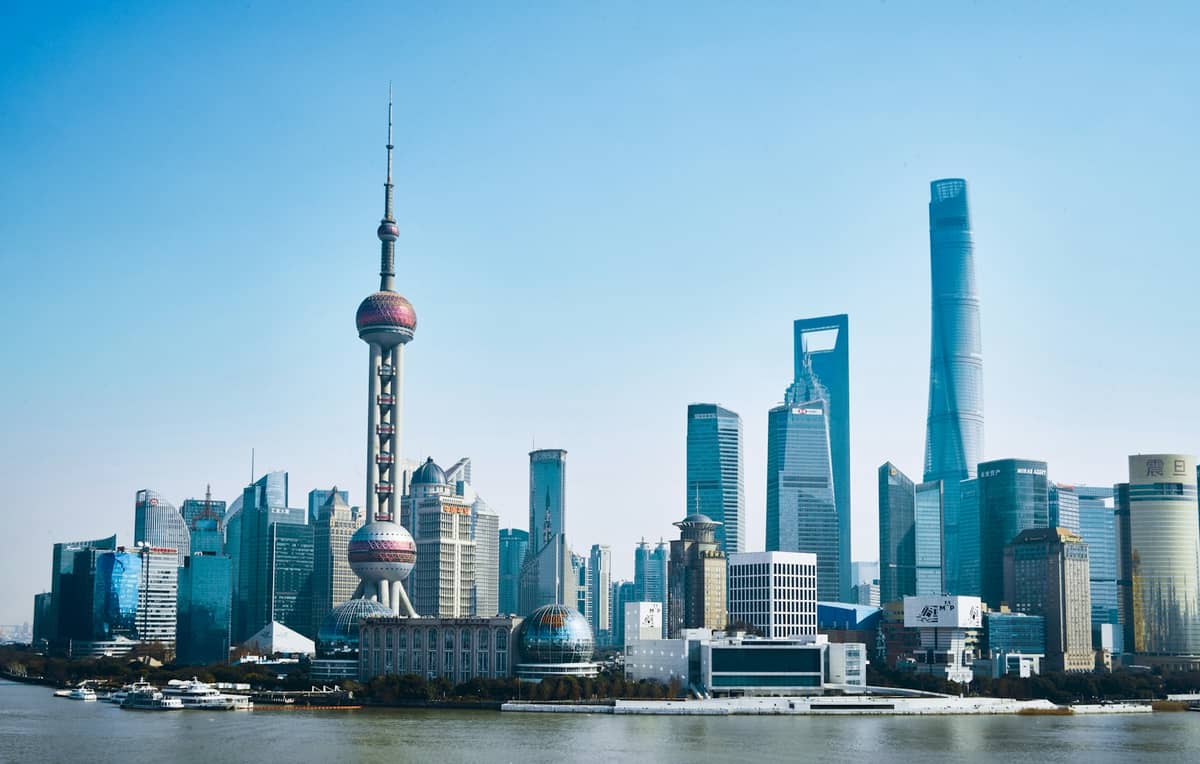 Blick tagsüber auf Shanghais Pudong-Skyline vom Bund aus, mit dem Oriental Pearl Tower, dem Shanghai Tower und anderen ikonischen Wolkenkratzern am Huangpu.