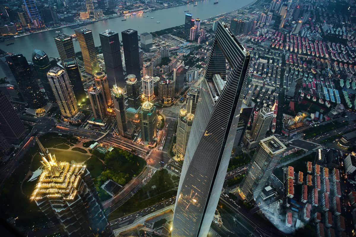 Hochgelegener Blick auf die Wolkenkratzer von Pudong in Shanghai in der Abenddämmerung, mit dem Shanghai World Financial Center und dem Jin Mao Tower in Flussnähe.