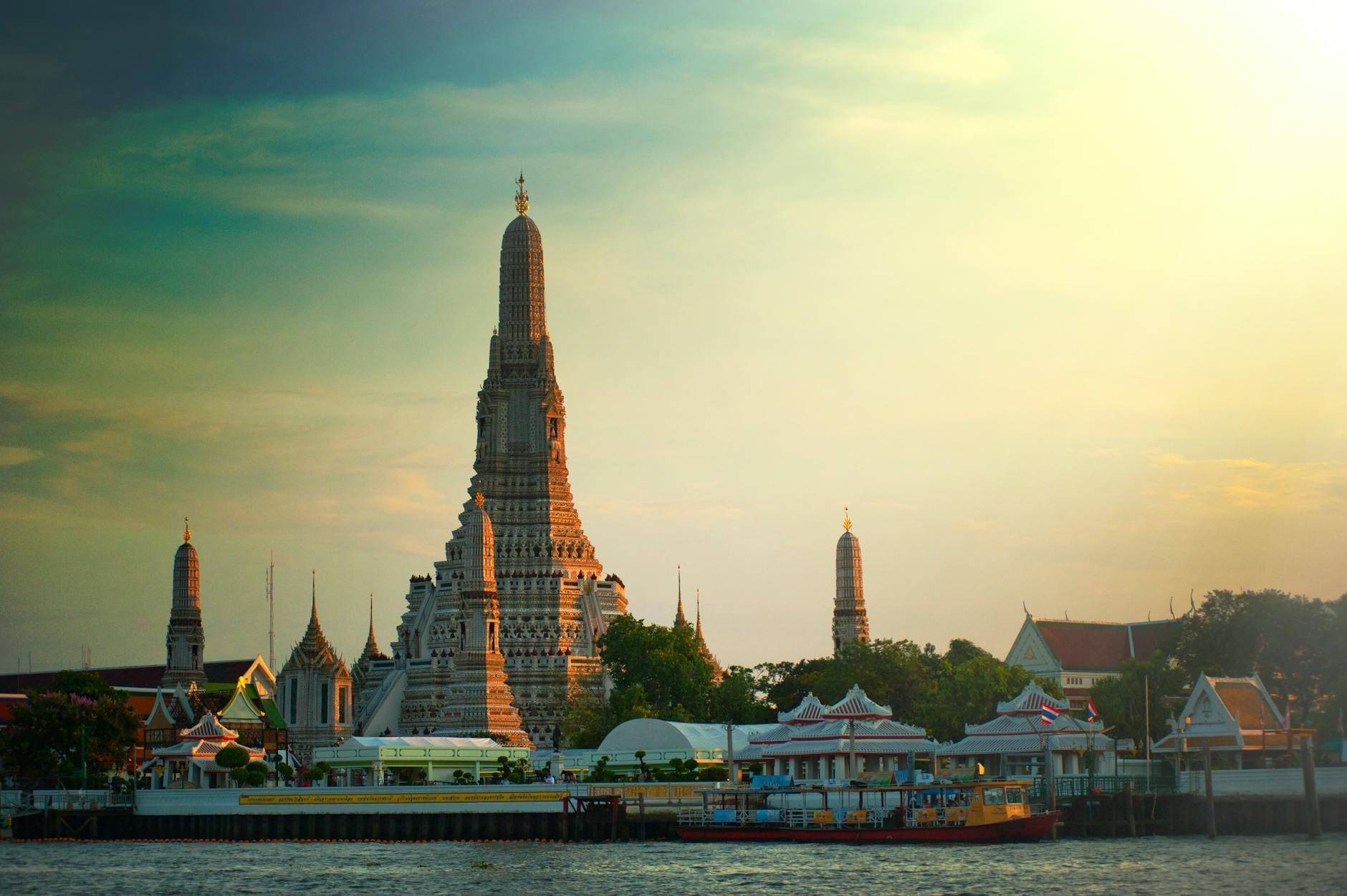 Templo Wat Arun ao pôr do sol às margens do rio Chao Phraya em Bangkok, com suas torres icônicas