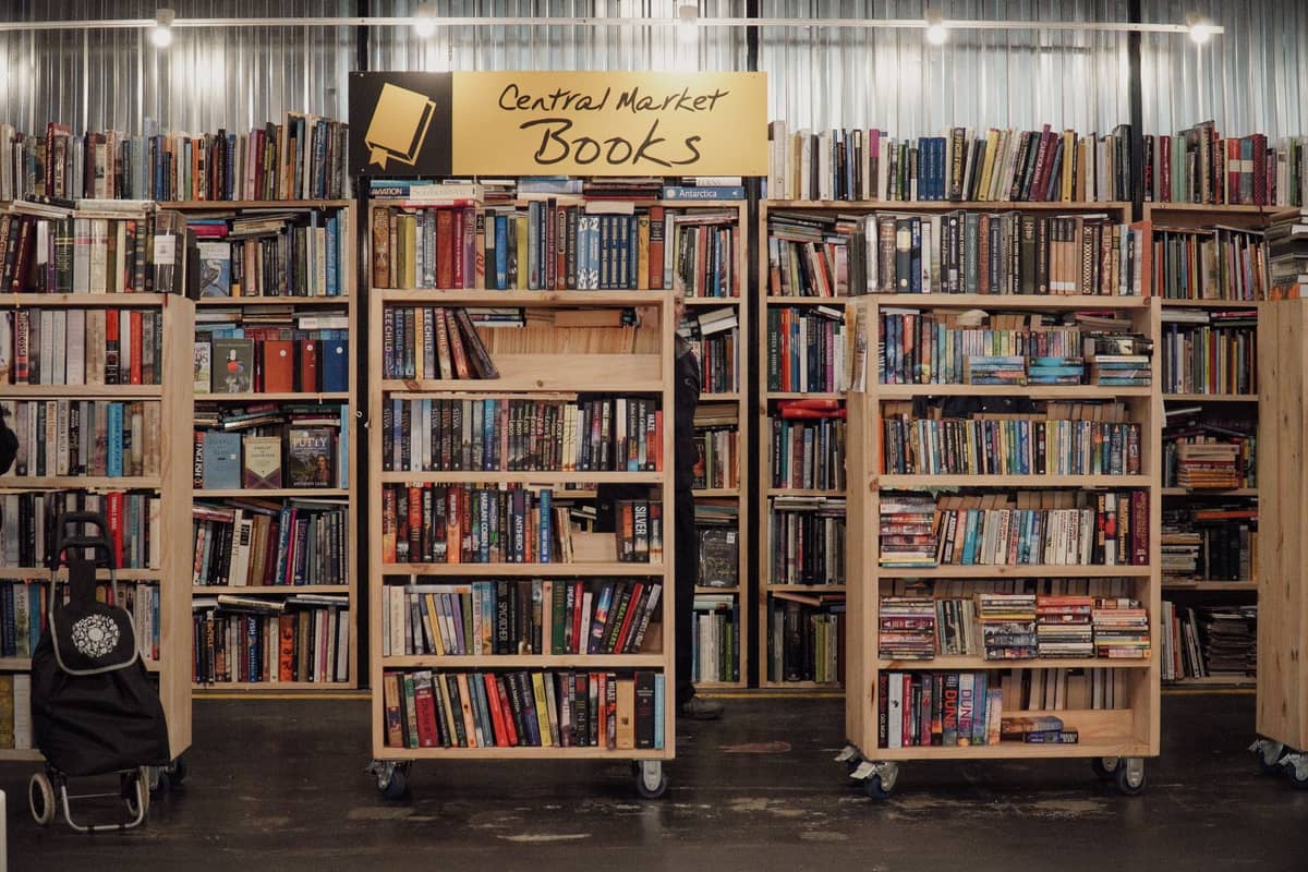 Bookshelves filled with books at Central Market Books in a cozy indoor marketplace setting.