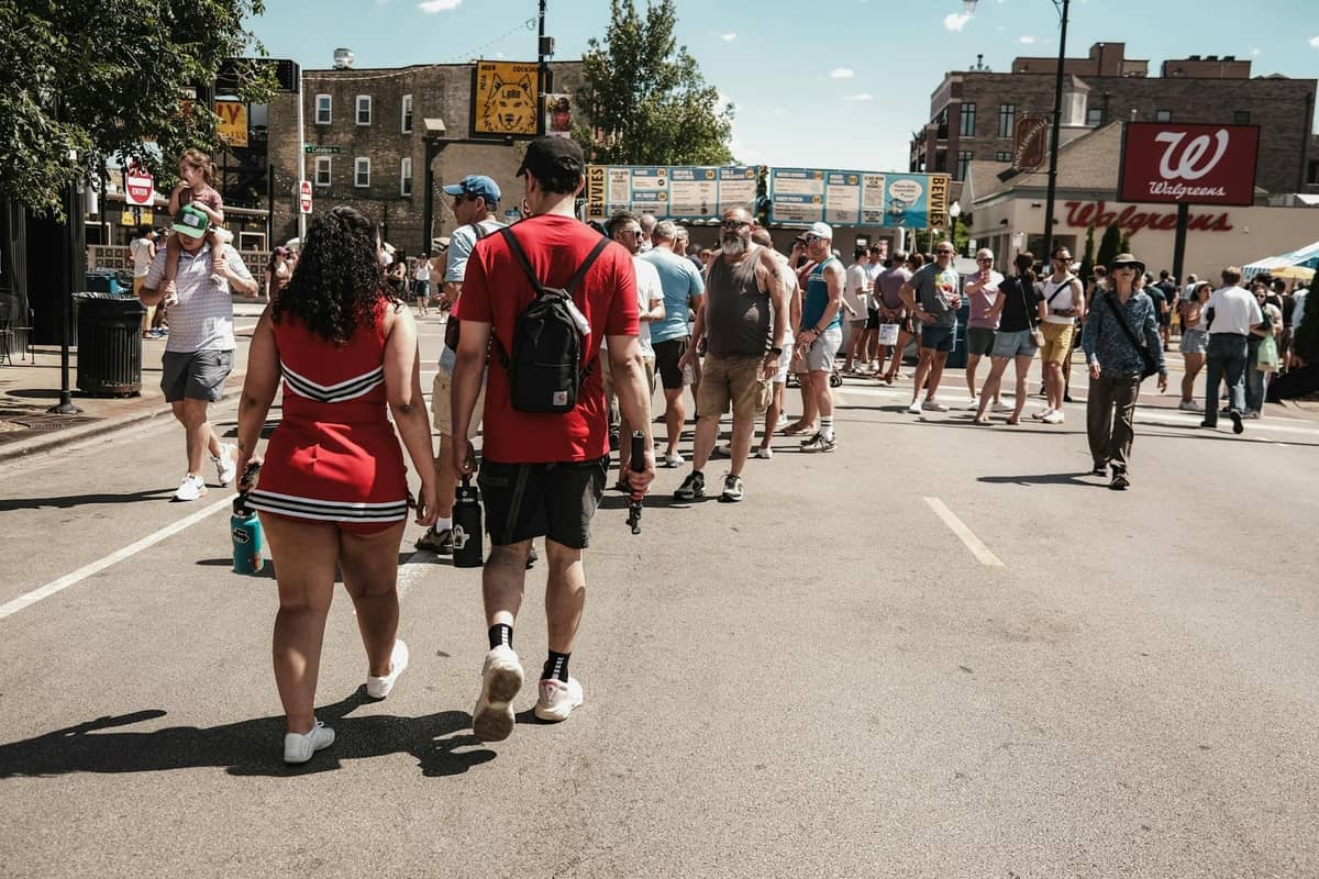 Belebte Straße in Chicago mit vielen Menschen an einem sonnigen Tag, Walgreens im Hintergrund sichtbar, typisch für die Hochsaison des Tourismus.