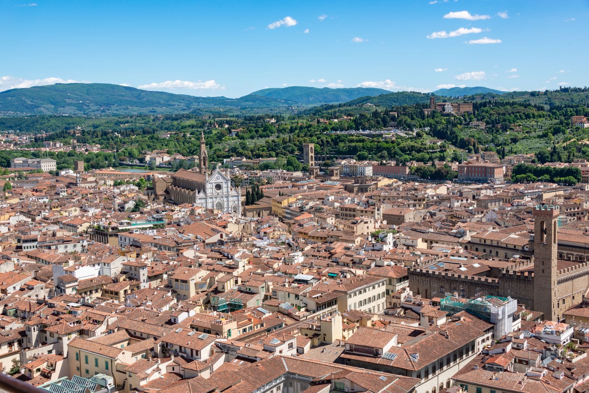 วิวพาโนรามาของเส้นขอบฟ้าเมืองประวัติศาสตร์ของฟลอเรนซ์ พร้อมด้วย Duomo หอระฆัง หลังคาดินเผา เนินเขาสีเขียว และท้องฟ้าใสสดใสในฤดูใบไม้ผลิ