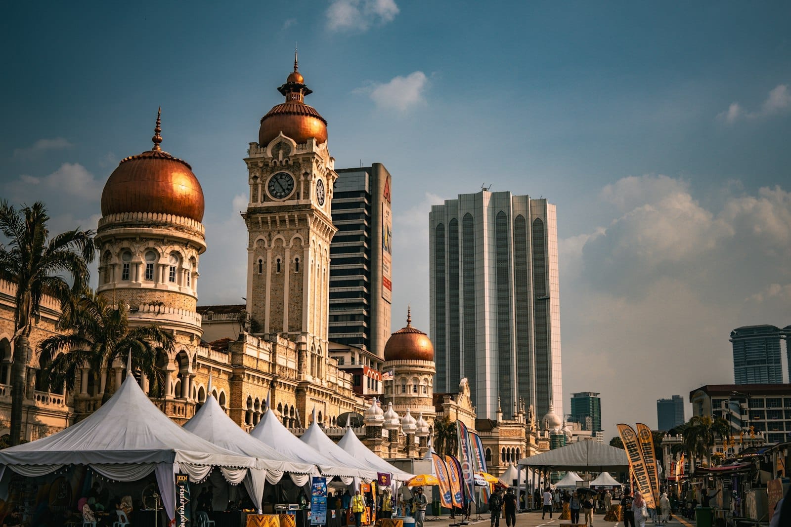 Vibrant aerial view of Kuala Lumpur's skyline from KL Tower at golden hour, showcasing iconic towers and urban expanse.