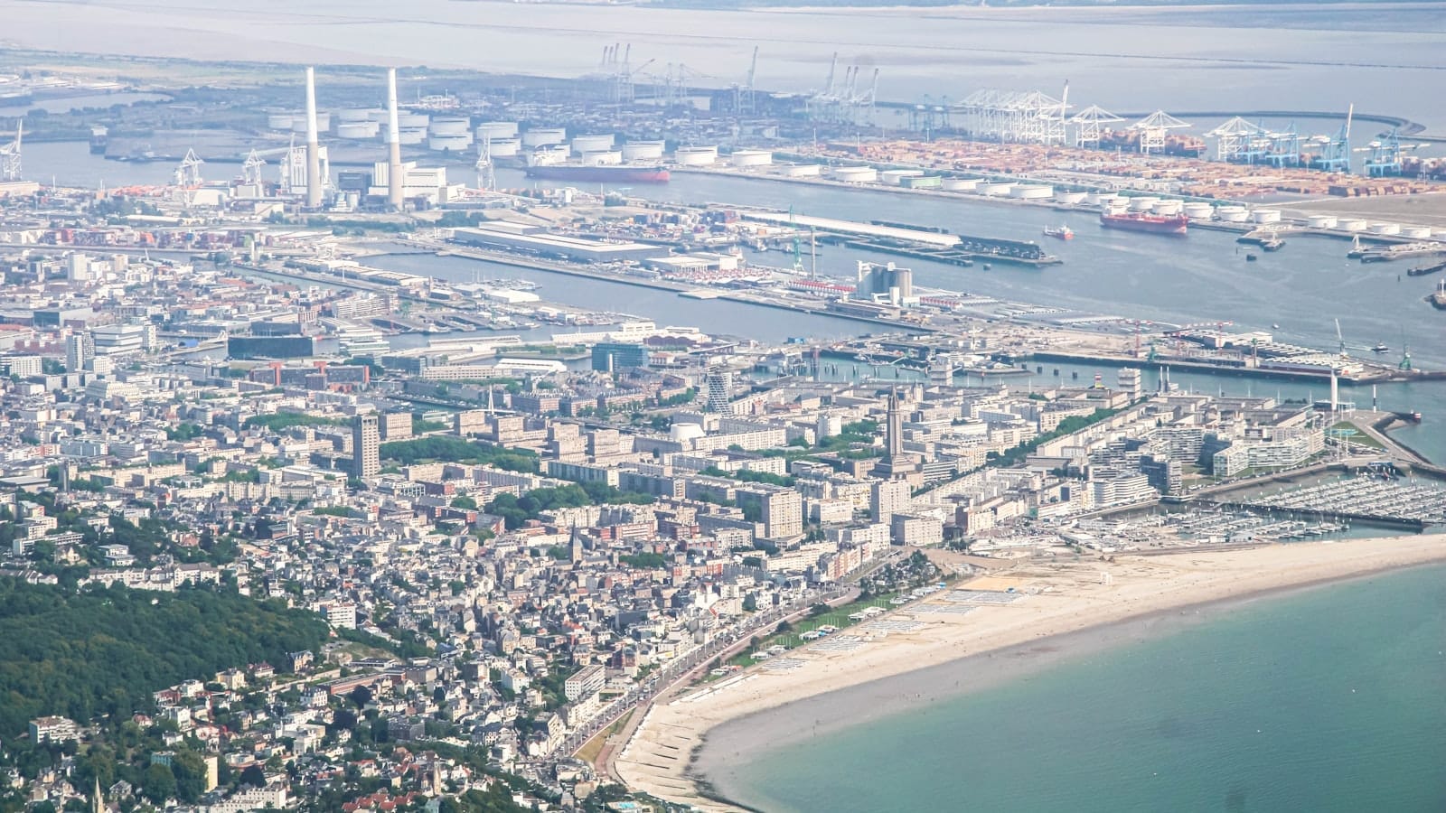 Aerial view of Le Havre showing the city, coastline, and port facilities under mild, partly cloudy weather.