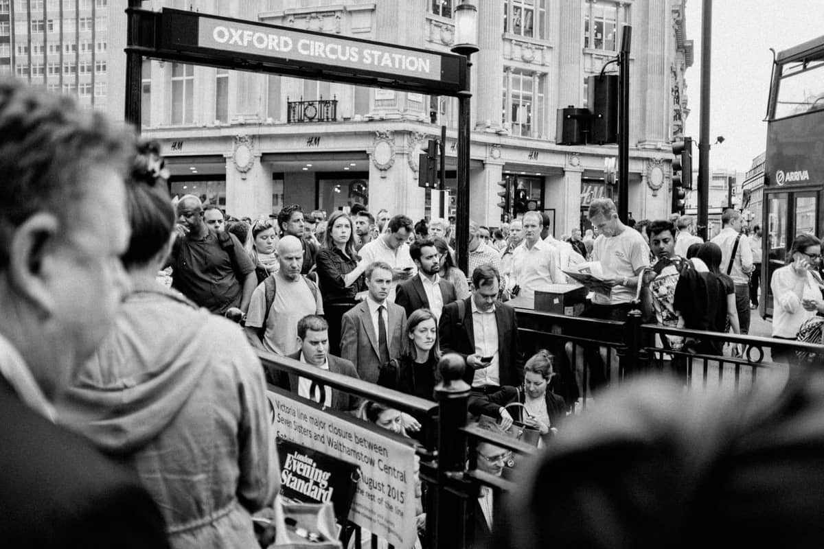Multidões de pessoas saindo da estação Oxford Circus em Londres durante um horário movimentado, ilustrando o pico de aglomeração e congestionamento.