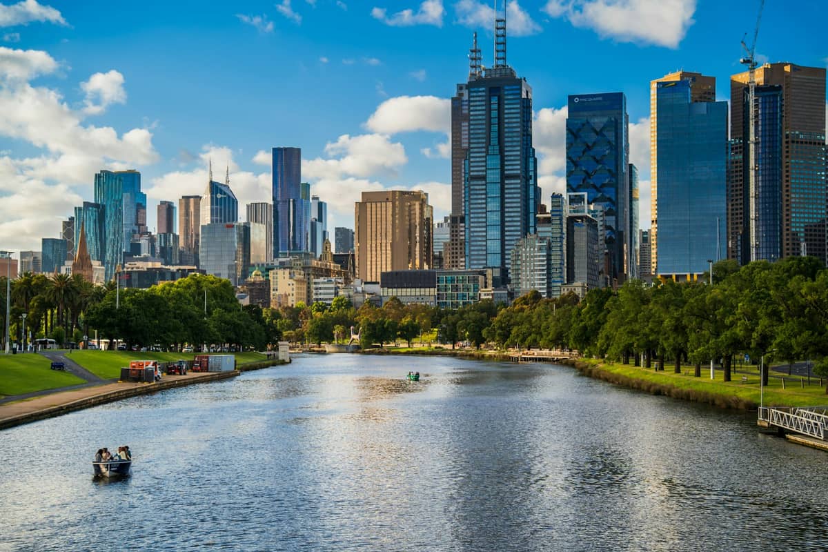 Tagesansicht der Skyline von Melbourne mit modernen Wolkenkratzern und dem Yarra River unter einem teilweise bewölkten blauen Himmel.