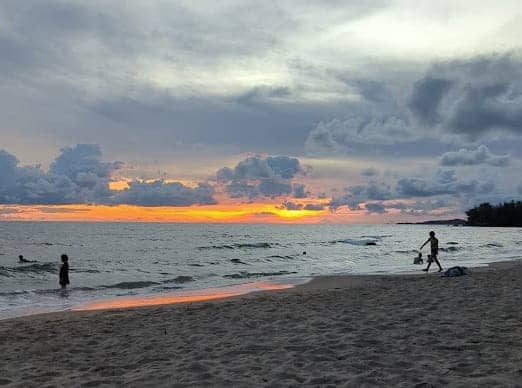 Phu Quoc beach at sunset with cloudy skies and gentle waves during rainy season