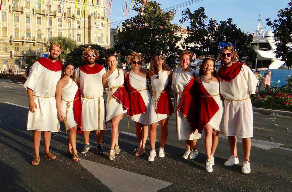 Eine Gruppe von Menschen in römischen Kostümen posiert auf einer Straße in Split während eines lebhaften Outdoor-Festivals oder einer Veranstaltung.