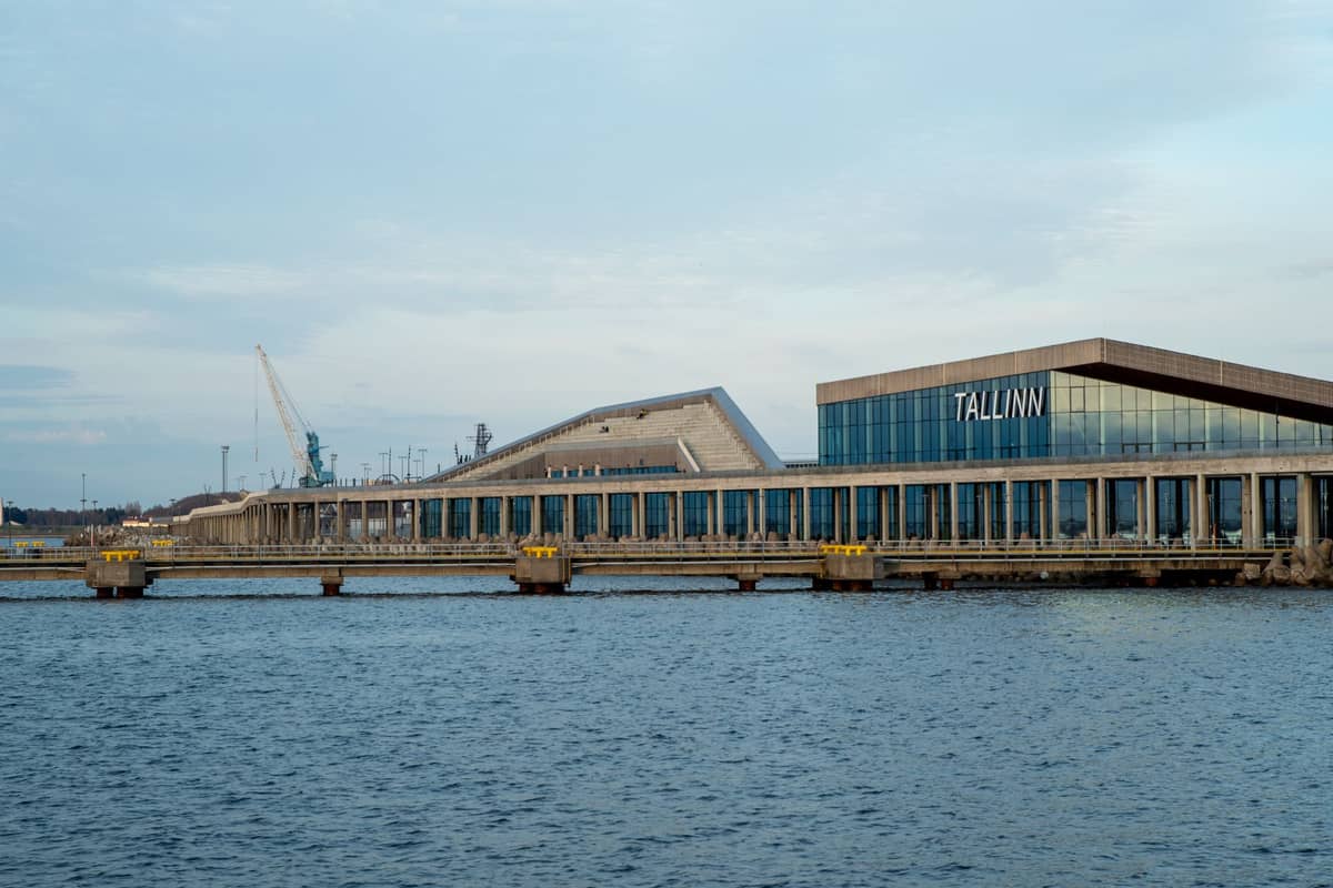Hafenterminal Tallinn mit modernen Glasgebäuden und dem Schriftzug 'TALLINN', von den blauen Gewässern des Hafens aus gesehen