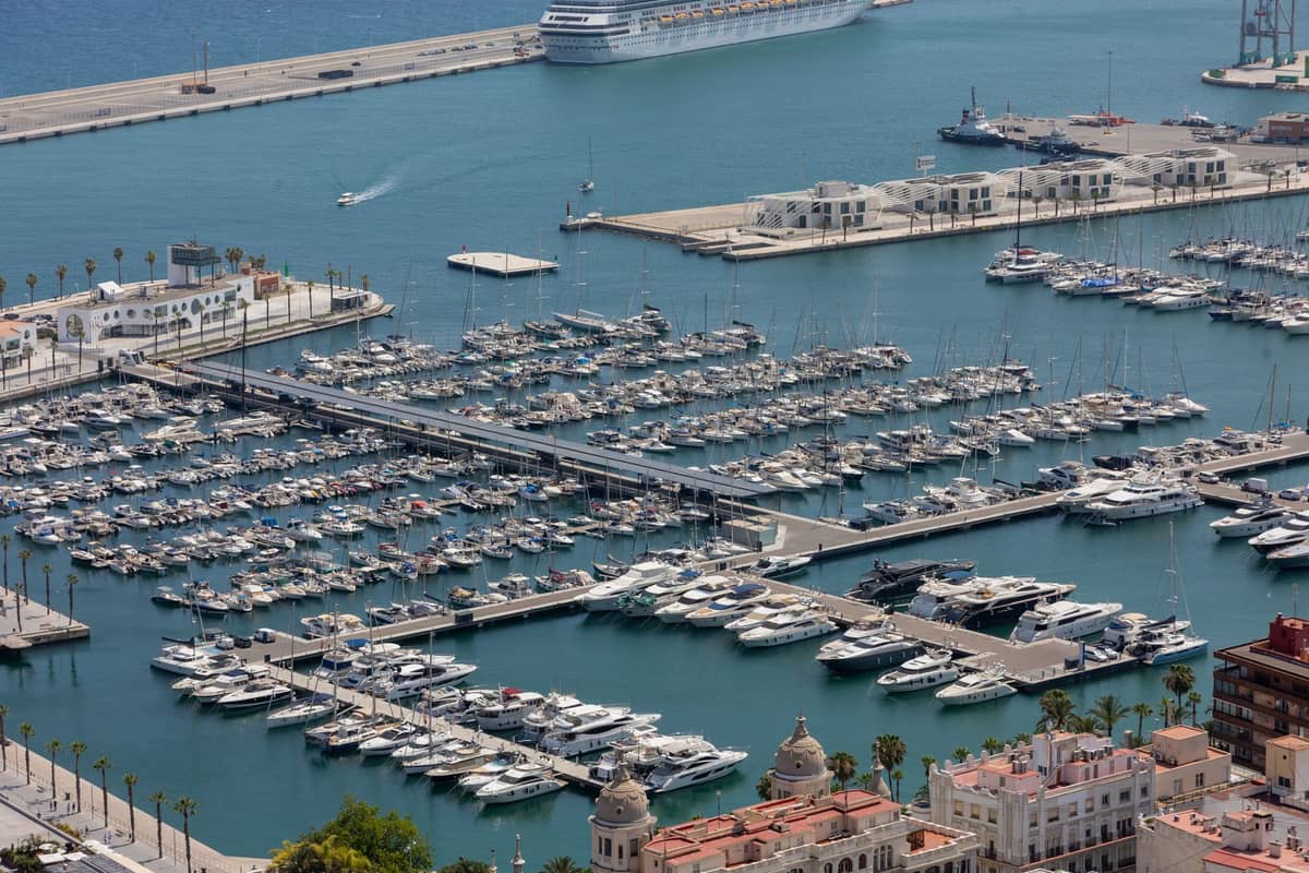 Vista aerea del porto turistico di Valencia con file di yacht e passeggiate fiancheggiate da palme lungo il lungomare.