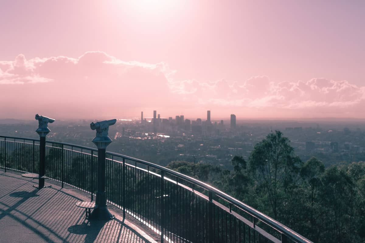 Vista panorámica del horizonte de Brisbane desde el mirador de Mount Coot-tha con terraza de observación y telescopios al amanecer o atardecer.