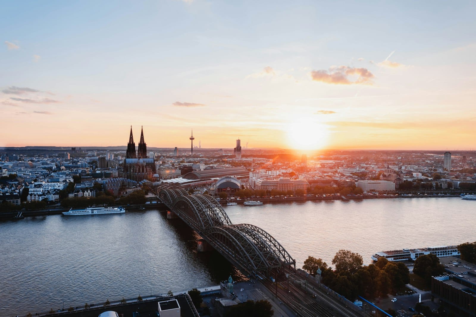 ภาพถ่ายทางอากาศแบบพาโนรามาของเมือง Cologne พร้อมมหาวิหาร สะพาน Hohenzollern และแม่น้ำ Rhine ยามพระอาทิตย์ตกดิน