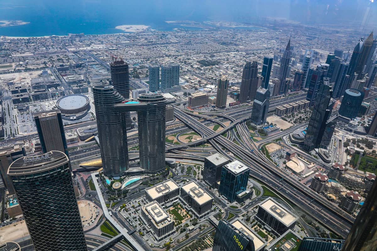 Tagsüber aufgenommene Luftansicht der Wolkenkratzer, Highways und Küstenlinie von Dubai von einem hohen Aussichtsdeck aus.