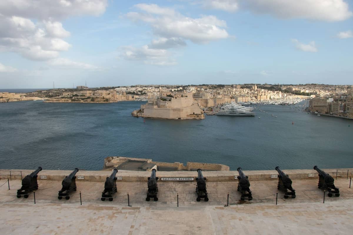 Punkt widokowy z armatami z widokiem na Grand Harbour oraz historyczne fortyfikacje i budynki nadwodne w Valletcie na Malcie.