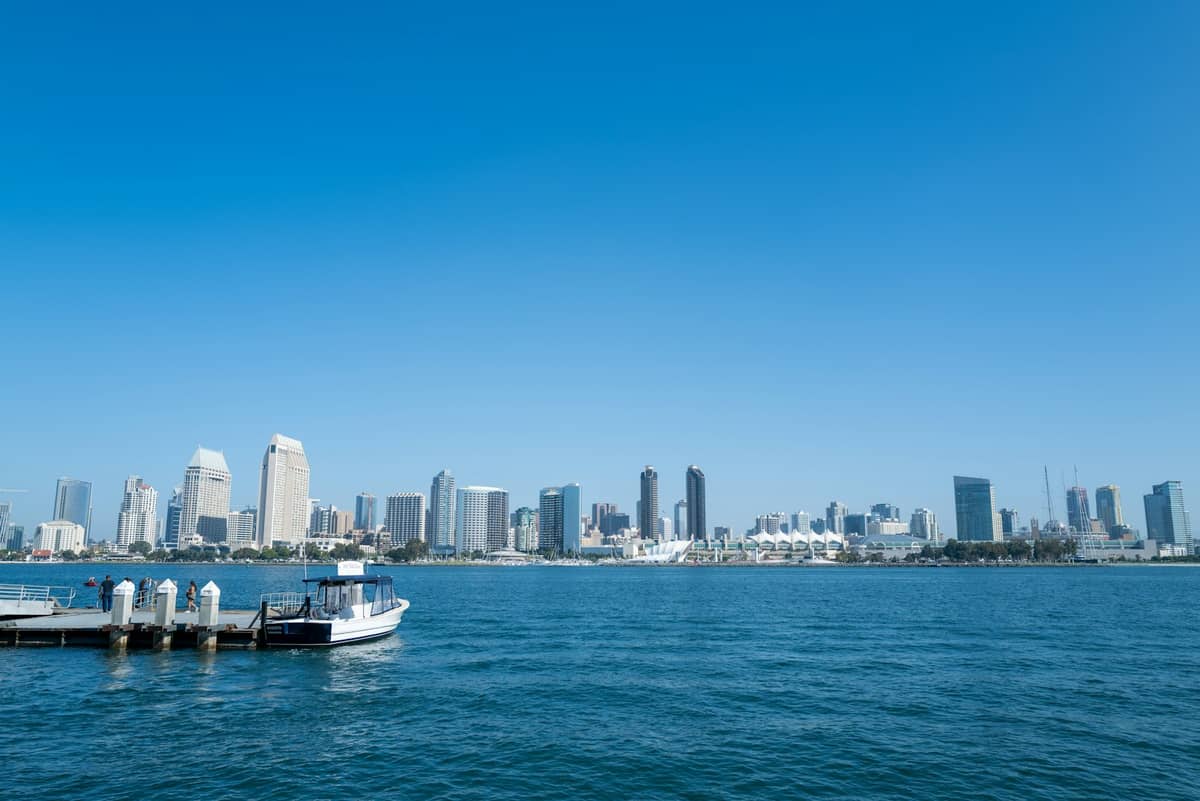 เส้นขอบฟ้าของ San Diego ฝั่งตรงข้ามอ่าวพร้อมท่าเทียบเรือขนาดเล็ก เรือ และท้องฟ้าสีฟ้าใส