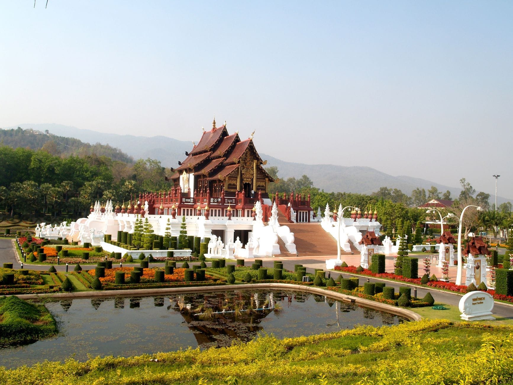 Khu vườn hoàng gia được chăm chút tỉ mỉ với hồ nước và nhà lầu kiểu Thái Lan, phía sau là sườn rừng Doi Suthep xanh mướt dưới bầu trời trong xanh tại Chiang Mai.