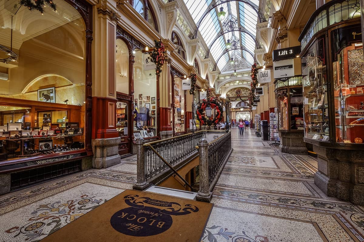 Innenansicht der Block Arcade in Melbourne mit Mosaikböden, kunstvollen Ladenfronten und dem verglasten Gewölbedach mit festlichen Dekorationen.