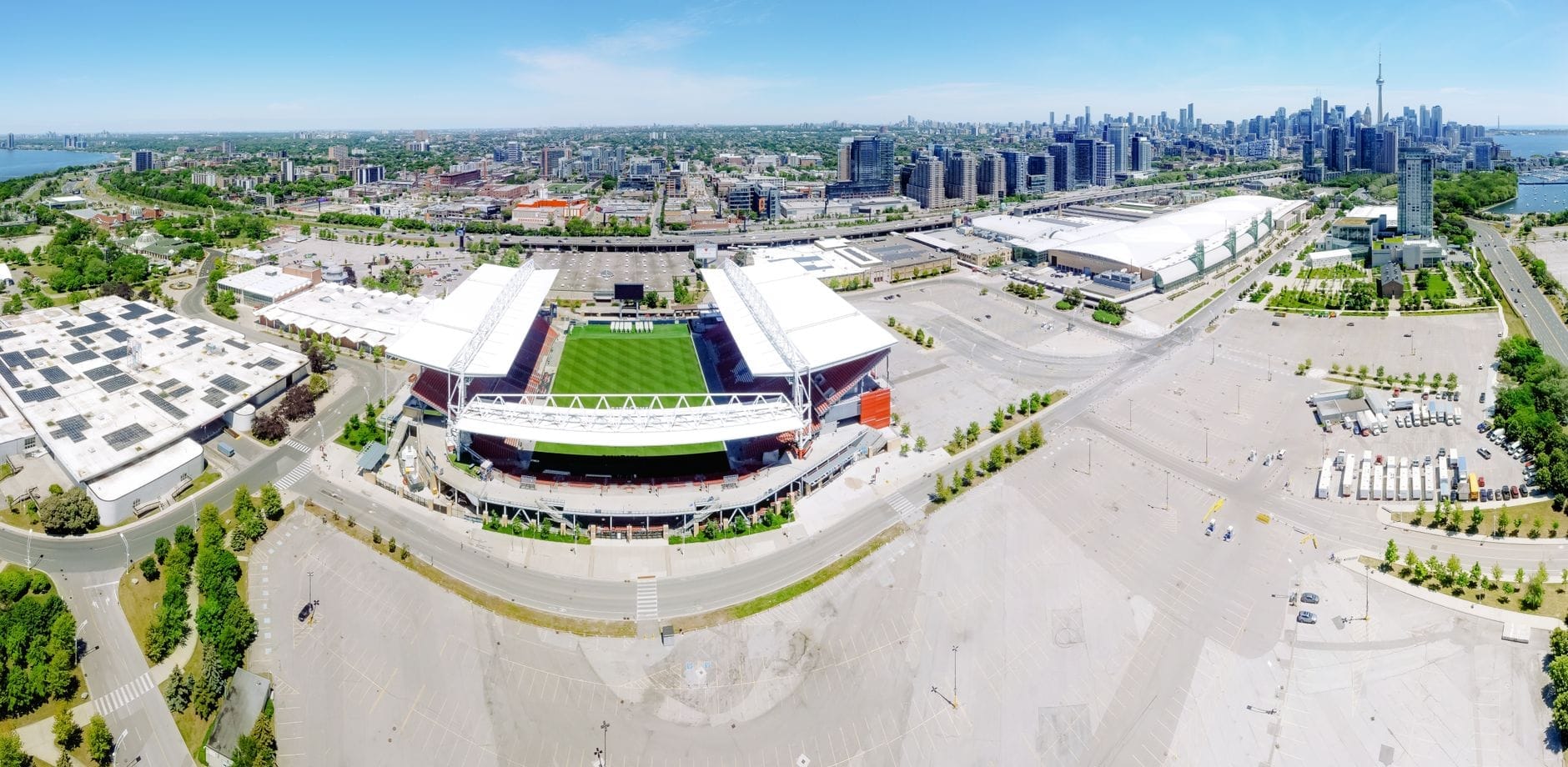 ภาพมุมสูงของ BMO Field ในโตรอนโต เห็นสนามชัดเจน สนามหญ้าเขียวสด ใกล้น้ำ และมีวิวเมืองโตรอนโตในวันที่แดดออกสดใส