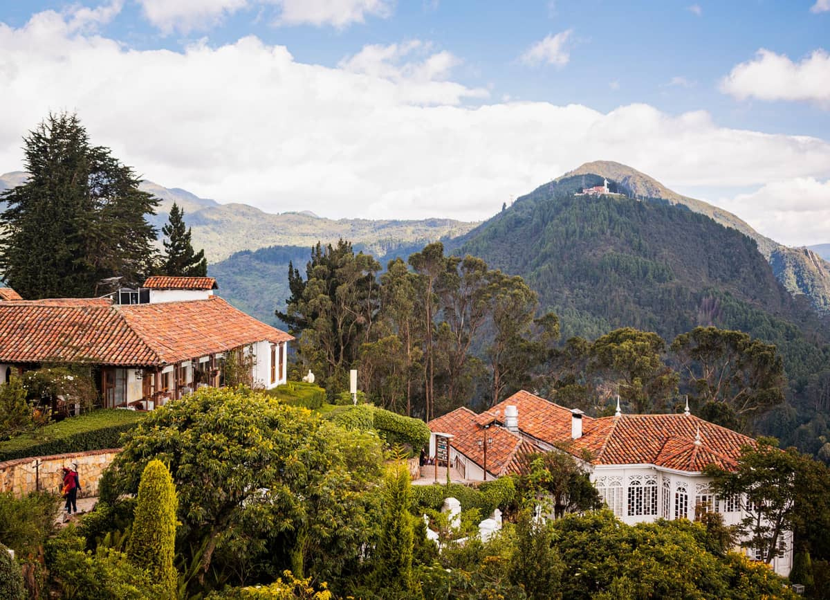 Bogotá's Monserrate mountain and historic buildings with lush greenery, showcasing major attractions at a high elevation.