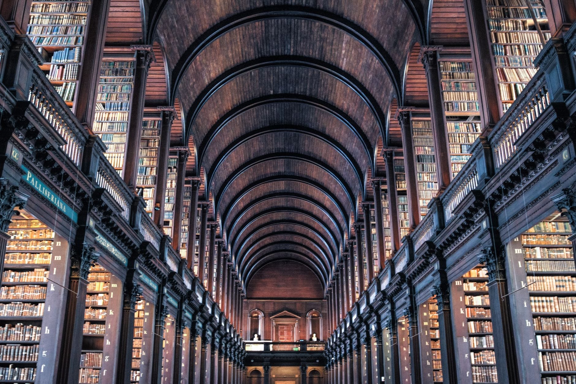 La celebre Long Room della Old Library del Trinity College di Dublino, con i suoi soffitti a volta in legno, l'illuminazione suggestiva e le imponenti scaffalature colme di antichi volumi.