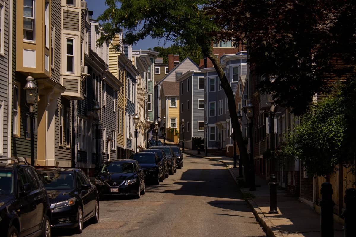 Wohnstraße in Boston mit Reihenhäusern und parkenden Autos, die die Viertel am Rande der Innenstadt veranschaulicht.