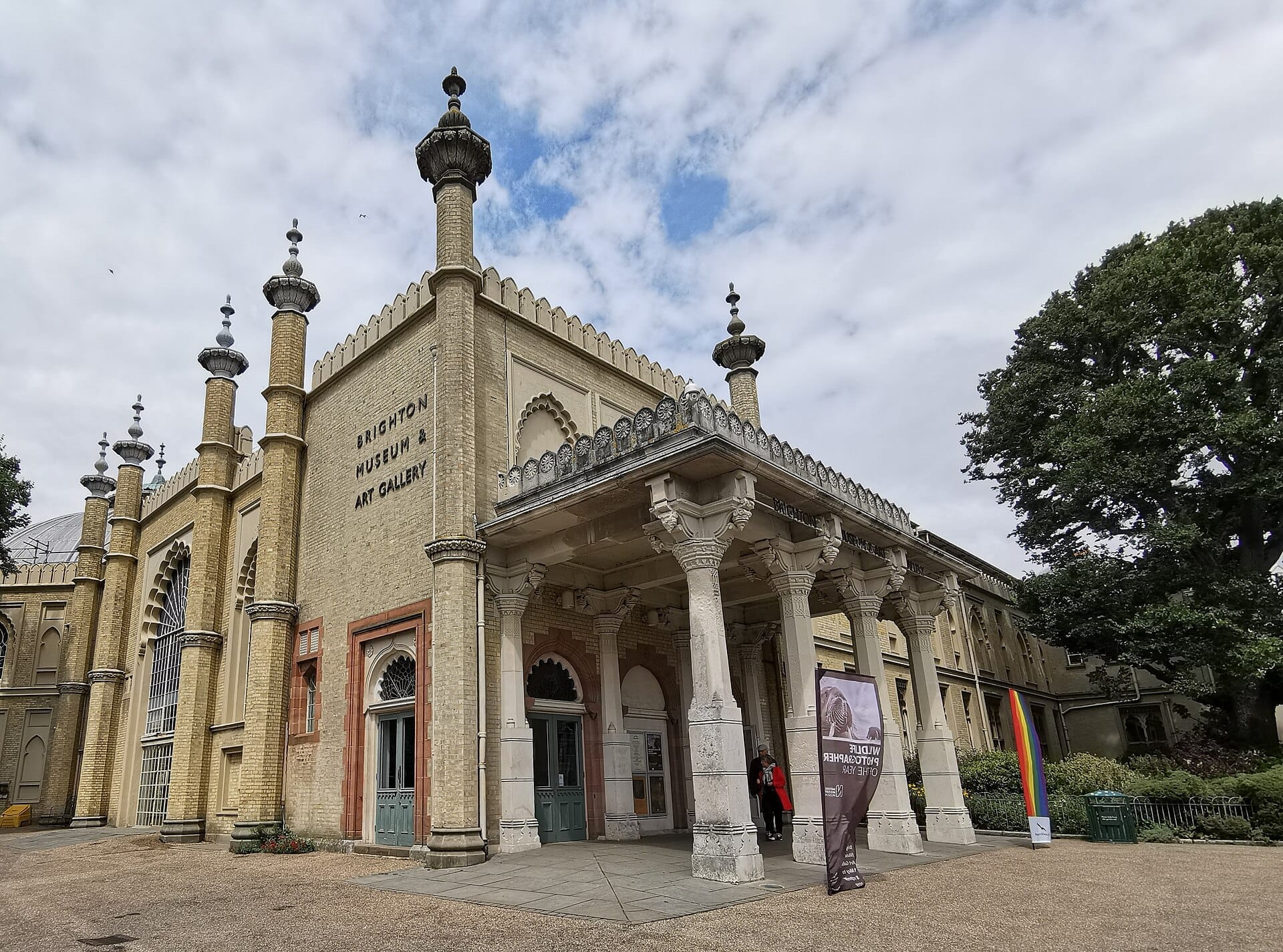 The Brighton Museum & Art Gallery’s ornate entrance with Indo-Saracenic columns, cream brickwork, and arched windows under a partly cloudy sky.