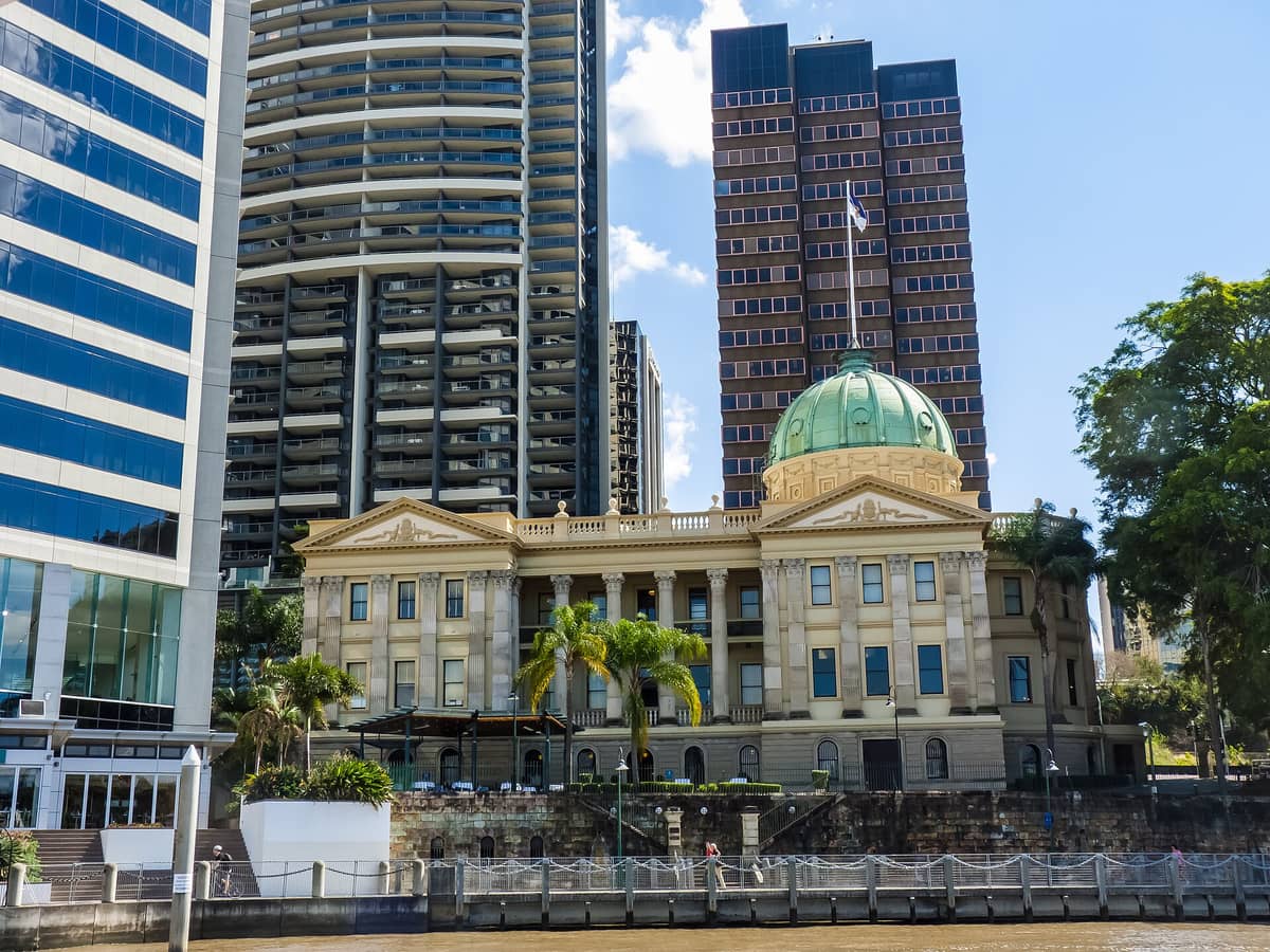 Das Brisbane Customs House vom anderen Flussufer aus, mit der markanten grünen Kuppel und klassischen Säulen vor der Kulisse moderner Wolkenkratzer.