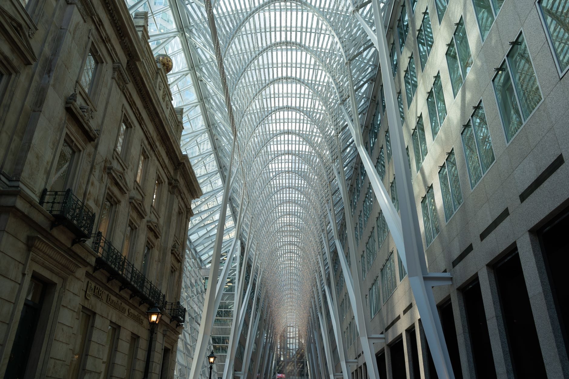 มุมกว้างของ Allen Lambert Galleria กับหลังคาโค้งเหล็กและกระจกสุดตระการตา โอบล้อมด้วยอาคารหินและกระจกใน Brookfield Place ใจกลางโตรอนโต