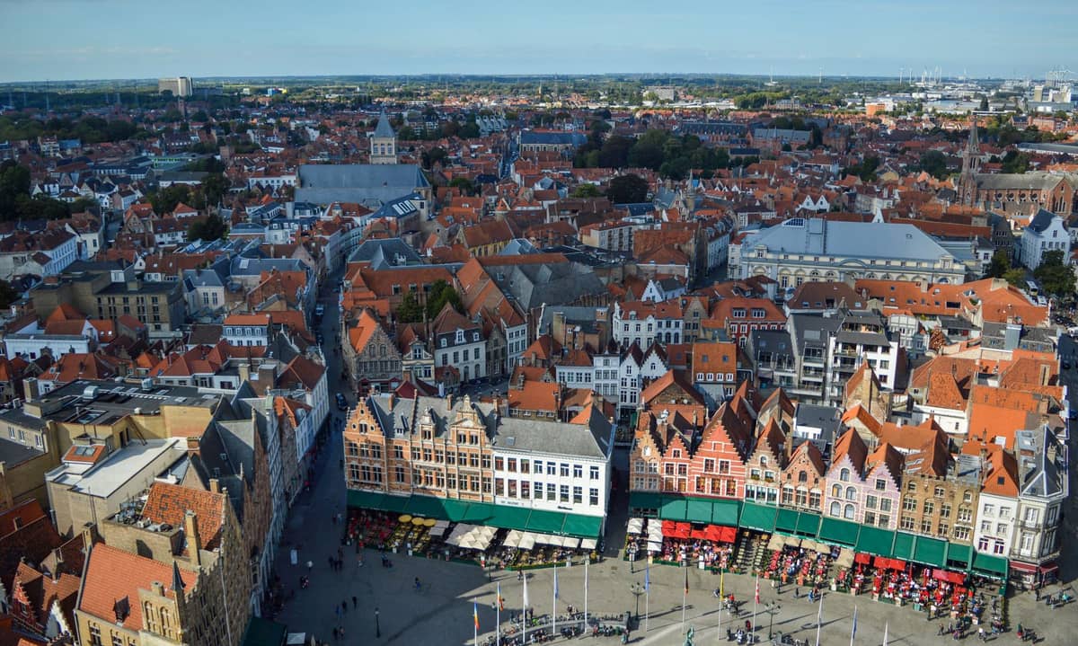 Aerial view of Bruges Markt square with iconic stepped gable houses and bustling square seen from above.