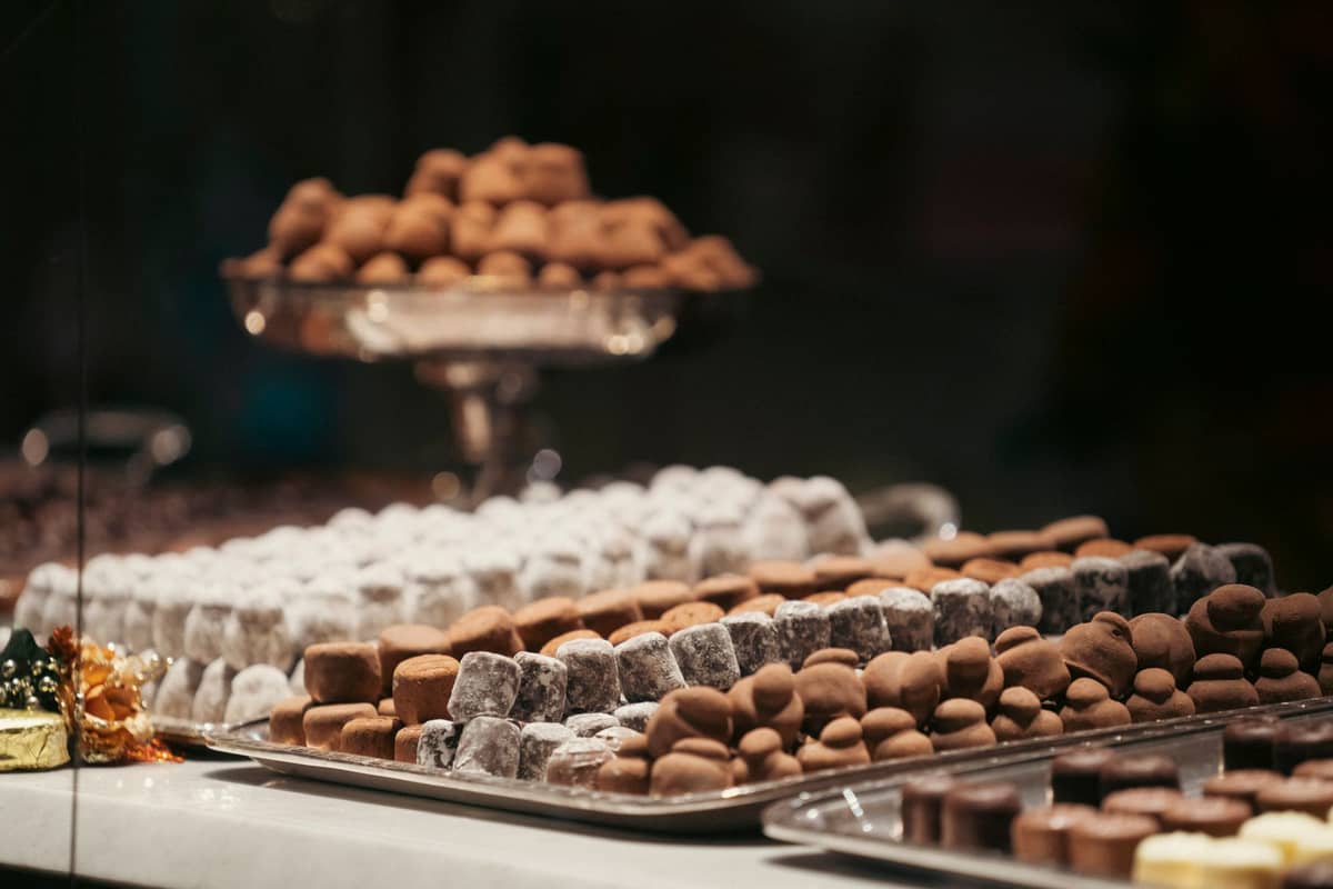 Trays of handmade Belgian chocolate truffles and pralines on display in a shop window in Bruges.