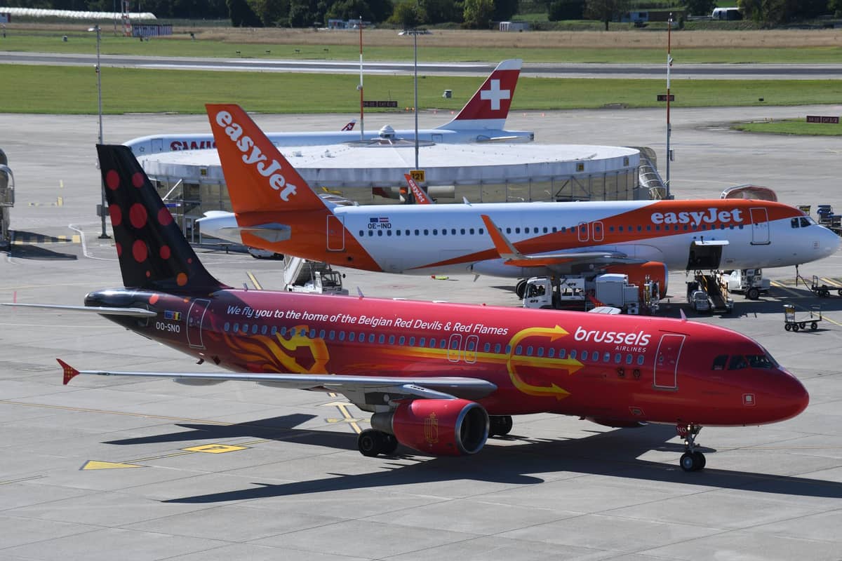 Avião da Brussels Airlines e aeronave da easyJet no tarmac do aeroporto, destacando diferentes companhias aéreas e áreas do aeroporto.