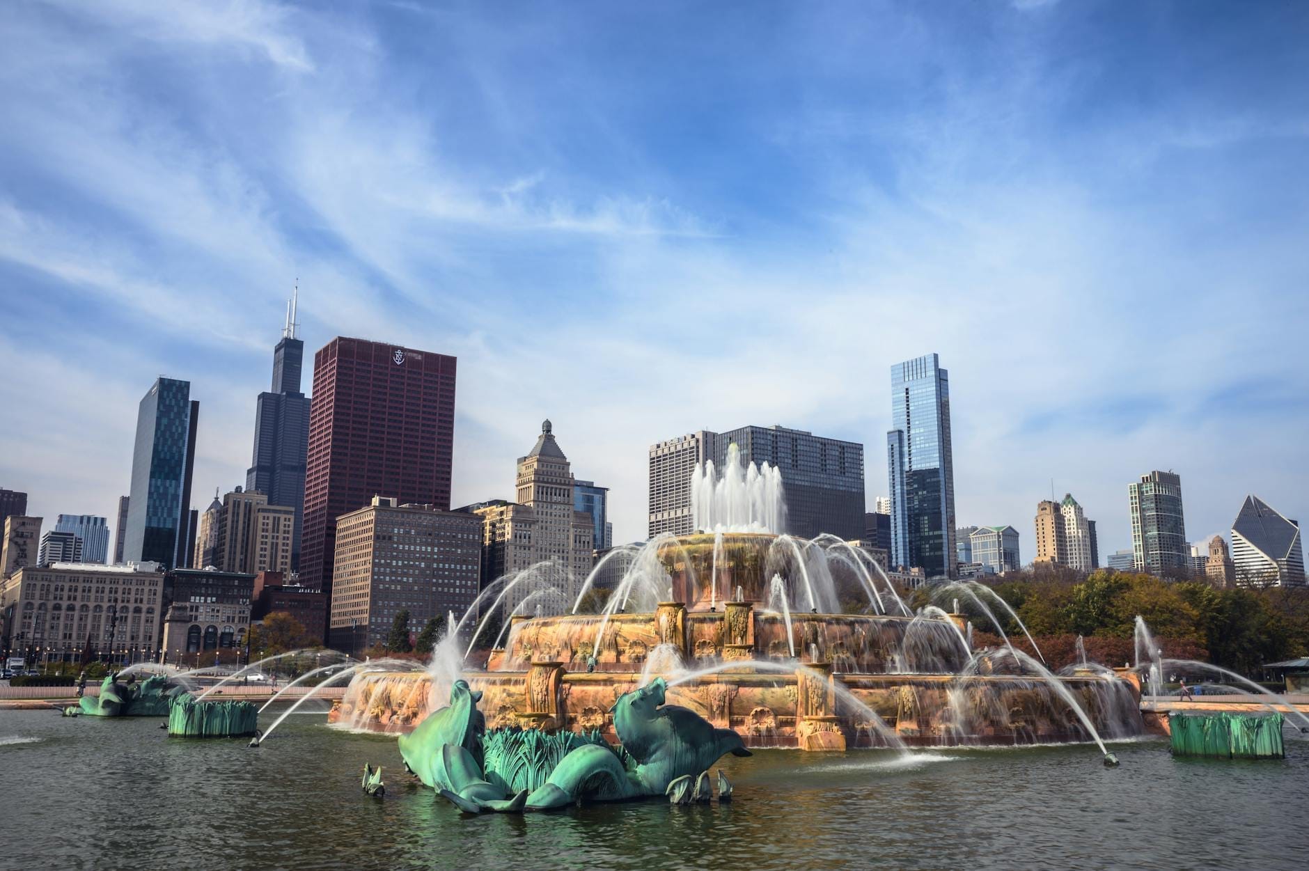 La Fontana Buckingham lancia getti d'acqua verso il cielo, incorniciata dallo skyline di Chicago sotto un cielo azzurro nel Grant Park.