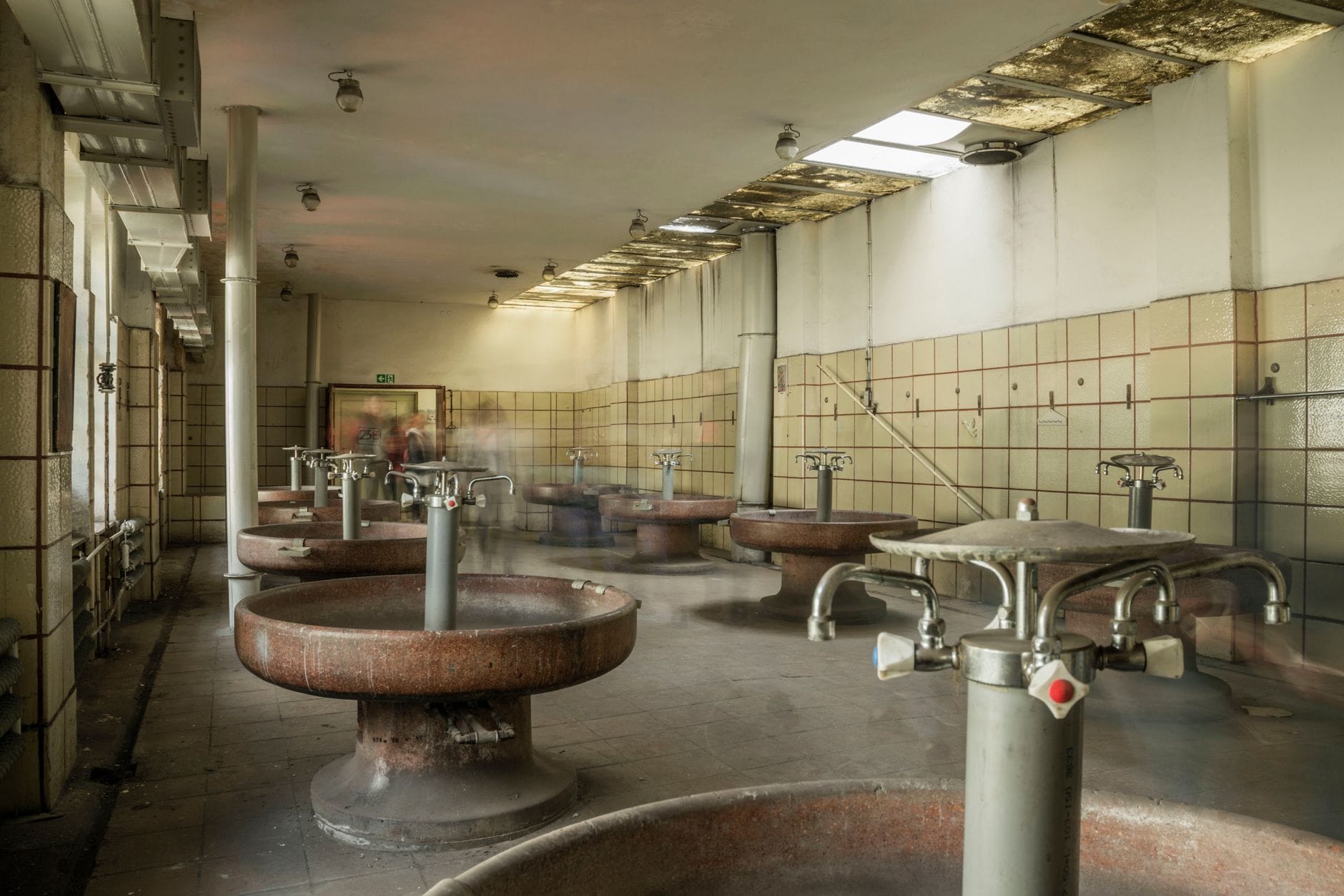 Innenraum eines historischen Thermalbades in Budapest mit runden Becken und gekachelten Wänden, der die berühmte Badekultur der Stadt widerspiegelt.