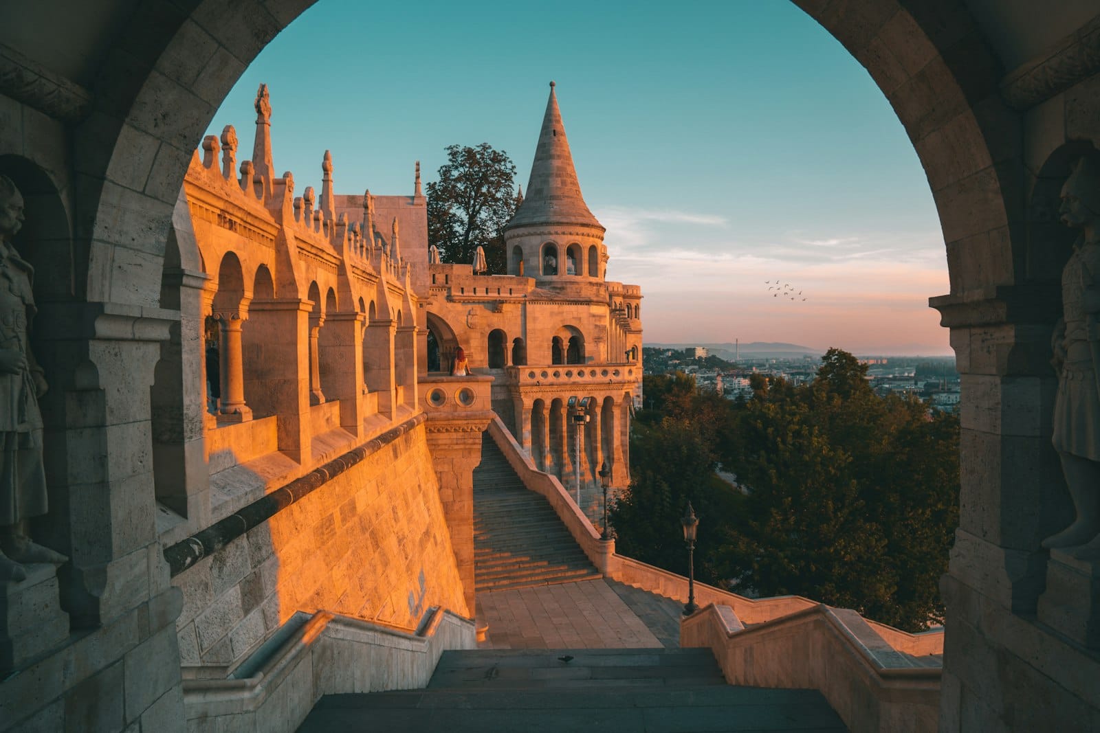 Morgensonne auf den Bögen und Türmen der Fischerbastei mit menschenleeren Gehwegen und weitem Blick über die Stadt – ein Gefühl von Entdeckung und verstecktem Budapester Charme.