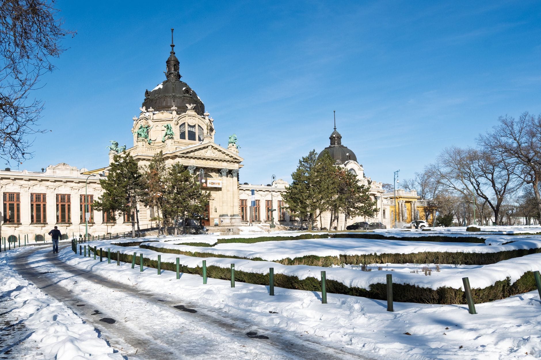 Verschneite Szene vor dem berühmten Széchenyi Thermalbad in Budapest mit blauem Himmel und klarem Winterlicht.