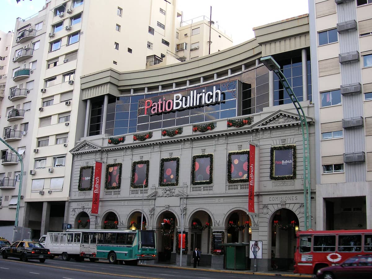 วิวภายนอกของ Patio Bullrich ห้างสรรพสินค้าขนาดใหญ่ใน Buenos Aires พร้อมป้ายและหน้าอาคารที่ตกแต่งอย่างสวยงามบนถนนที่คึกคัก