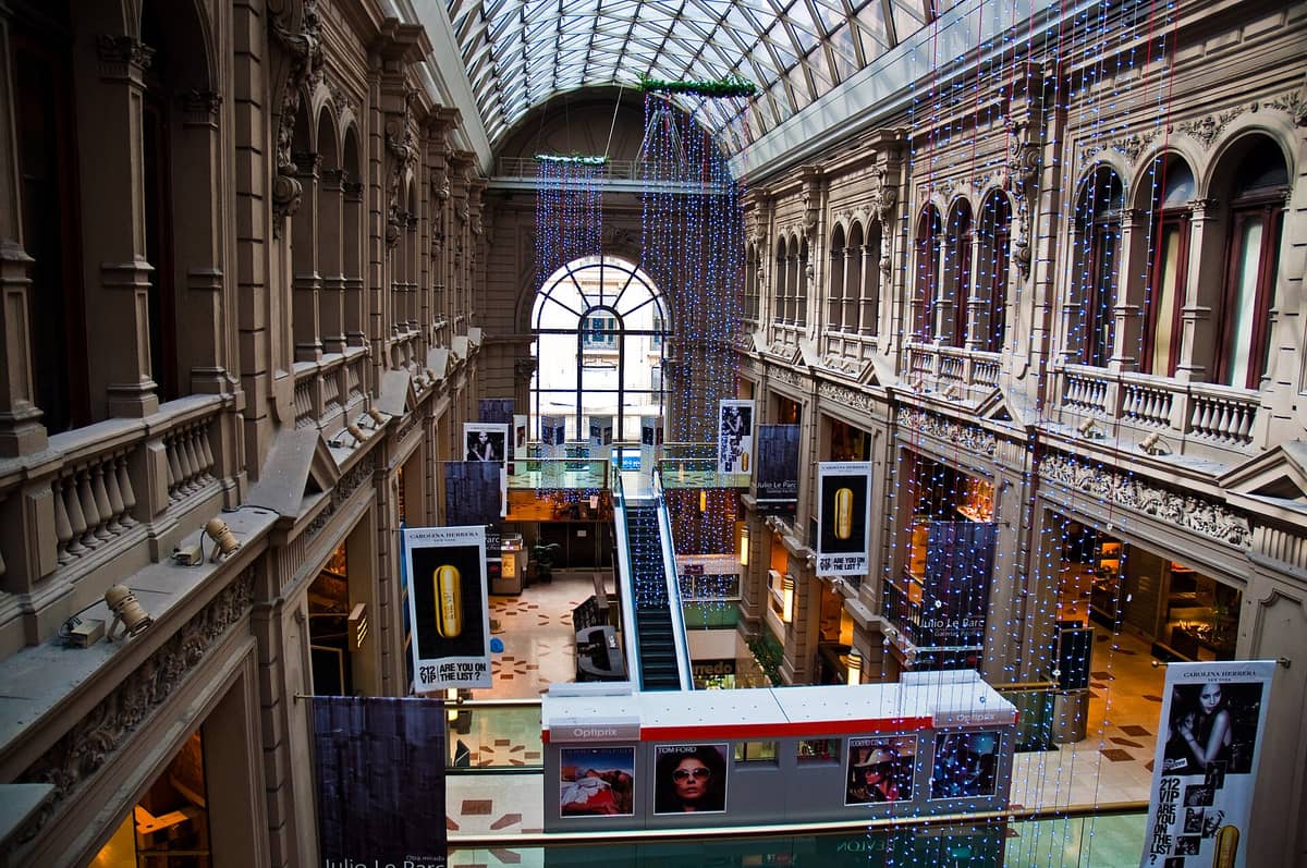 วิวภายในห้างสรรพสินค้า Galerías Pacífico ในบัวโนสไอเรส แสดงให้เห็นสถาปัตยกรรมประดับประดา หลังคากระจก ร้านค้า และไฟประดับแขวนเฉลิมฉลอง