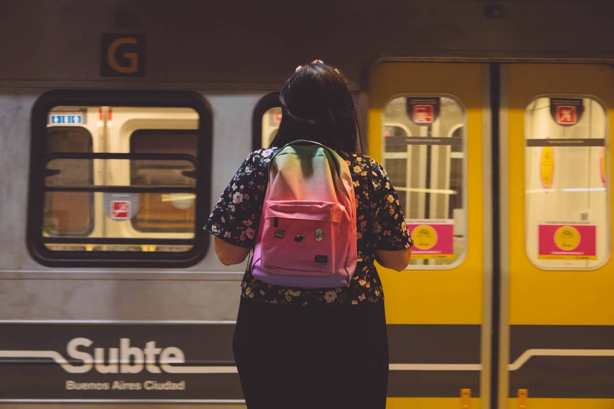 บุคคลที่สะพายเป้สีชมพูรอรถไฟใต้ดิน Buenos Aires Subte สีเหลืองที่สถานีใต้ดิน