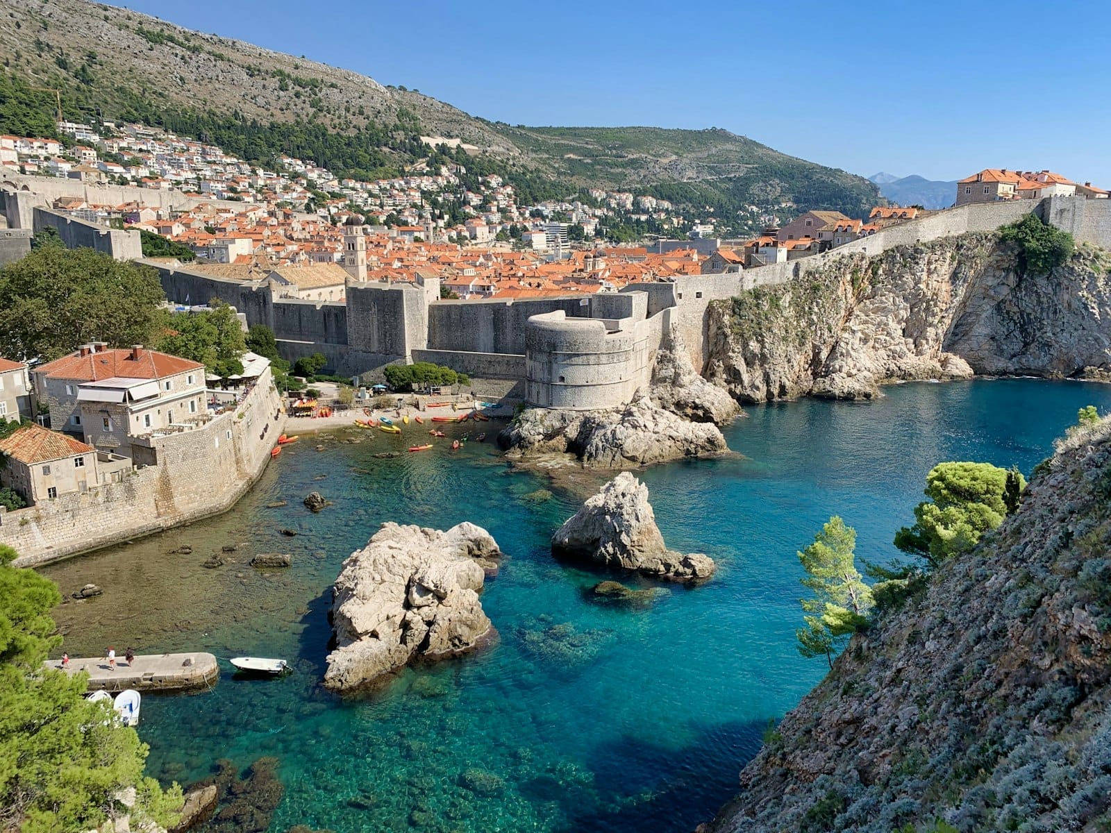 Vue lumineuse et dégagée des anciens remparts, des falaises et de la mer turquoise de Dubrovnik par beau temps, montrant le paysage côtier près du Buza Bar.