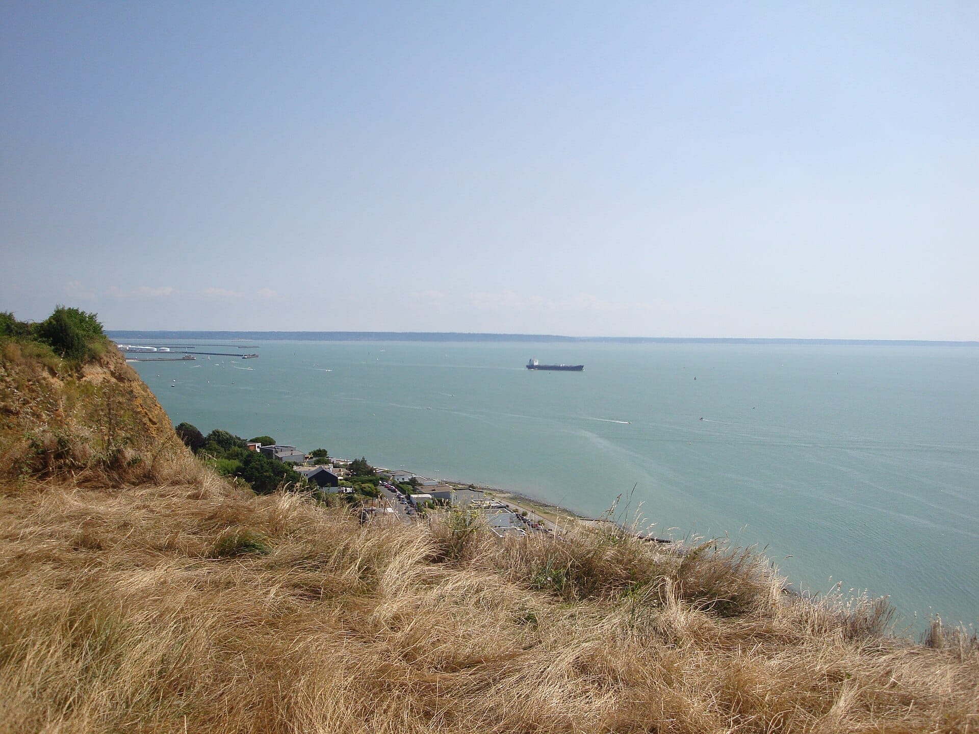 วิวจาก Cap de la Hève ที่มีหน้าผาชอล์ก หญ้าแห้ง ท้องฟ้าสีฟ้า และเรือขนส่งสินค้าลำหนึ่งอยู่ห่างออกไปบนช่องแคบอังกฤษ