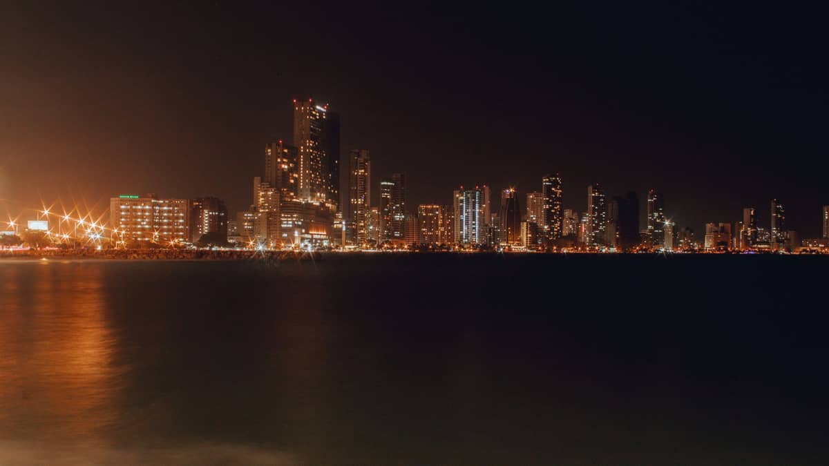 Nighttime view of Bocagrande’s modern waterfront skyline lit up with city lights reflecting on the water in Cartagena, Colombia.